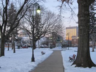 A photo looking down a park path to a statue of cavalry general Casimir Pulaski on a winter morning.
