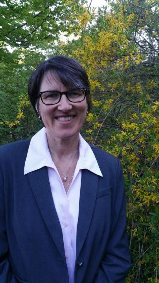 Portrait Image of SNHPC's Executive Director, Sylvia von Aulock, smiling in front of a leafy background.